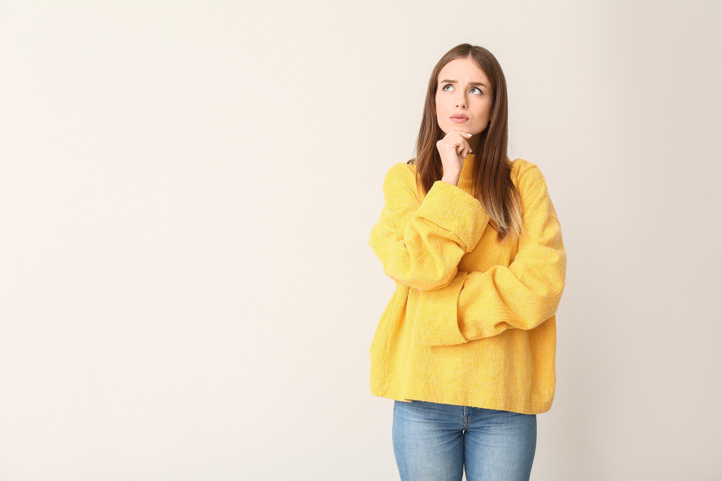 Thoughtful Young Woman on Light Background